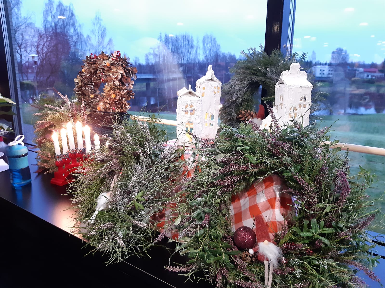 Joulumarkkinat Kuvassa joulukransseja ikkunan ääressä.