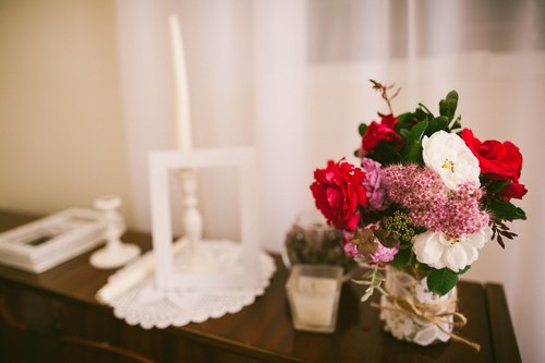Muistopöydällä on valokuva vainajasta, kynttilöitä ja kukkia.